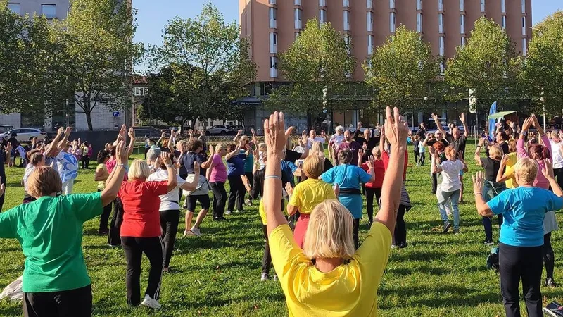 Skupina ljudi telovadi na prostem