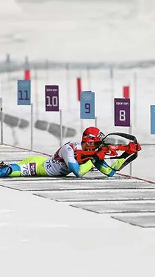 Slovenski biatlonec meri v tarčo med streljanjem na olimpijskih igrah v Sočiju 2014